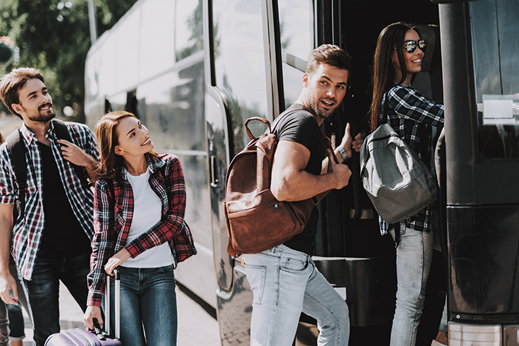 PEople smiling loading a long distance charter bus in Miami